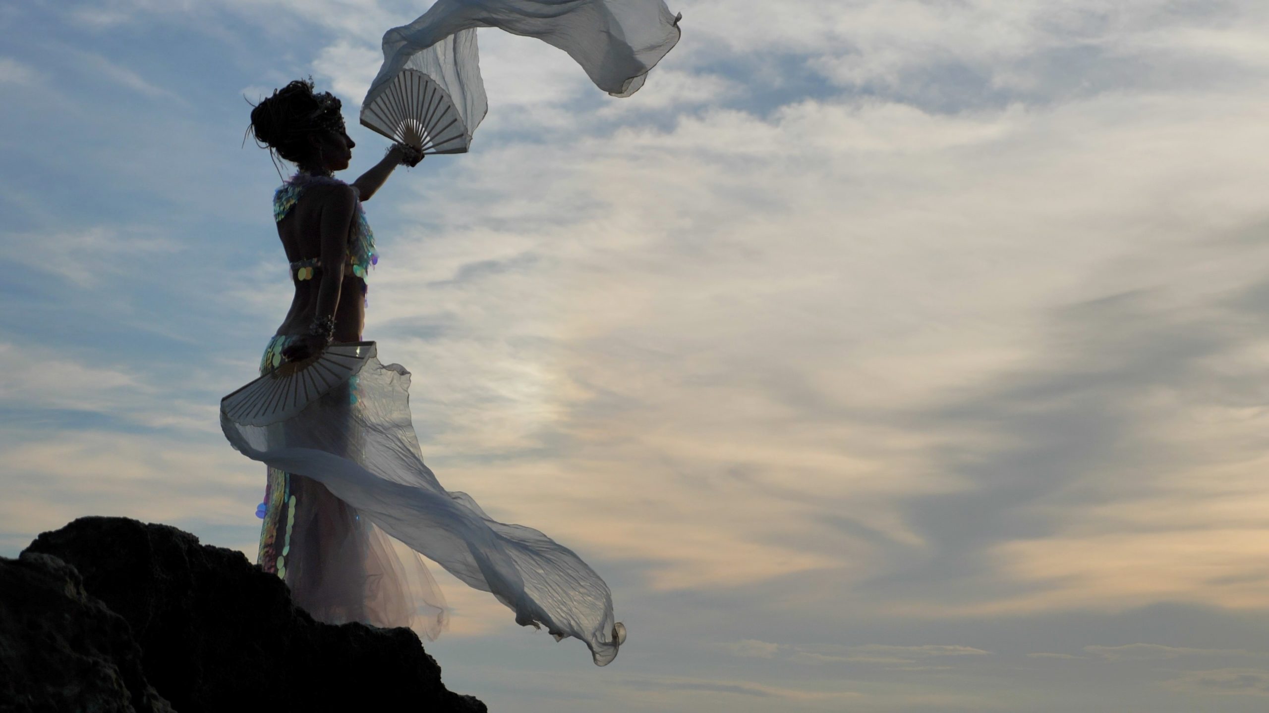 Fairy woman posing at sea rocky shore